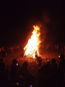 Gent envoltant una espectacular foguera de Sant Joan