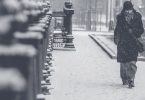 Noia camina per una ciutat nevada