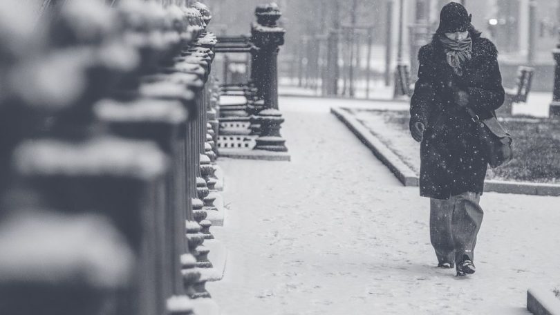 Noia camina per una ciutat nevada