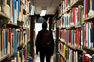 Estudiant al passadís d'una biblioteca