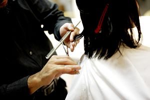 Perruquera tallant el cabell a una clienta